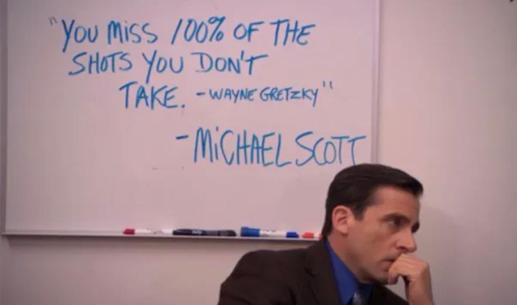 Michael Scott from The Office in front of a whiteboard reading “You miss 100% of the shots you don’t take. -Wayne Gretzky” -Michael Scott
